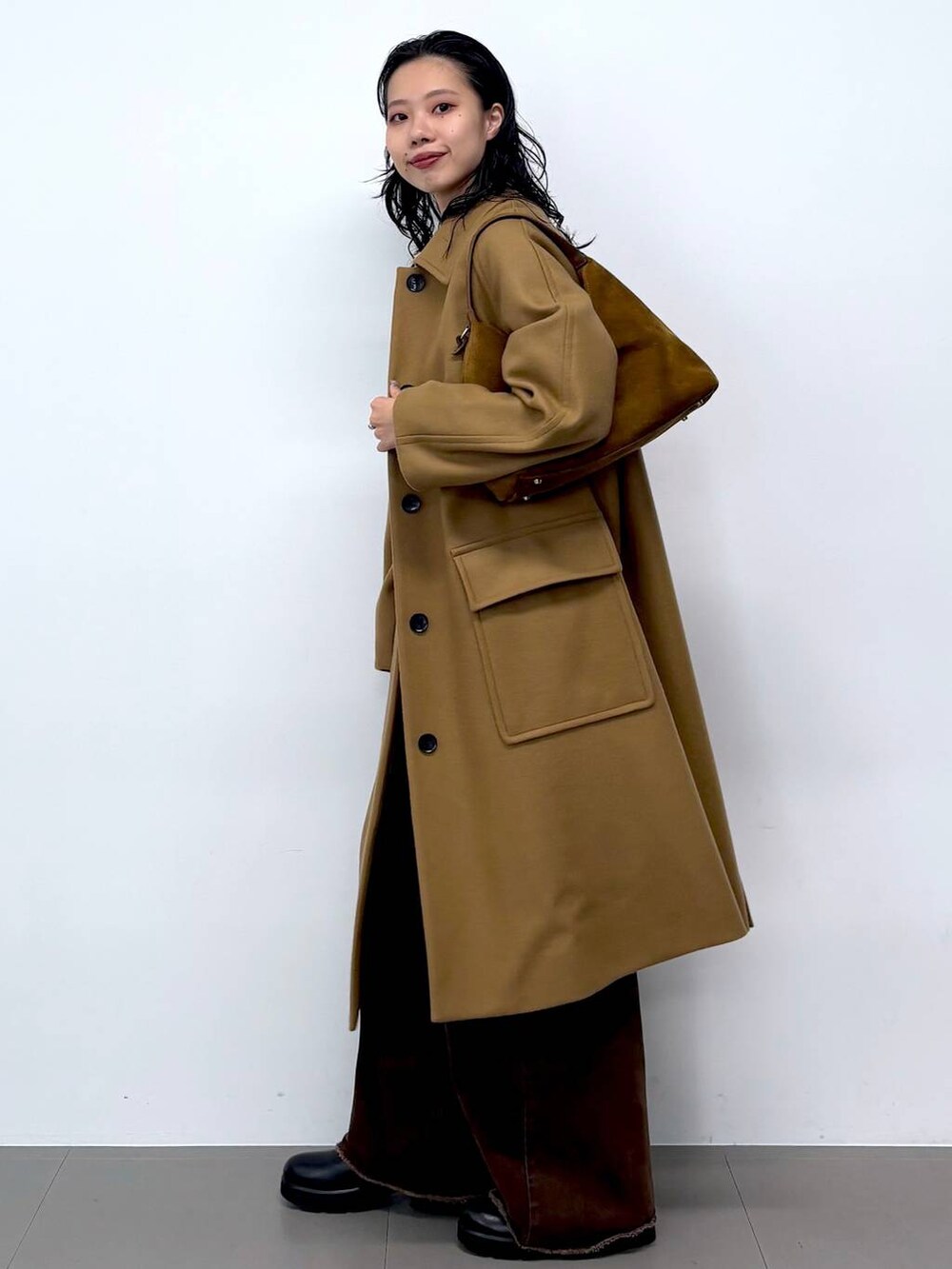 ブルー系のニット/セーター、ブラック系のサンダル、イエロー系のステンカラーコートを着用したレディースの秋コーディネートの9枚目の写真