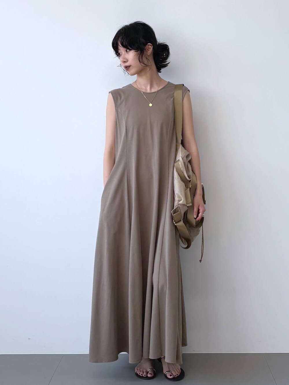 ブラック系のサンダル、ブラウン系のワンピース、ベージュ系のバックパック/リュックを着用したレディースの夏コーディネートの7枚目の写真