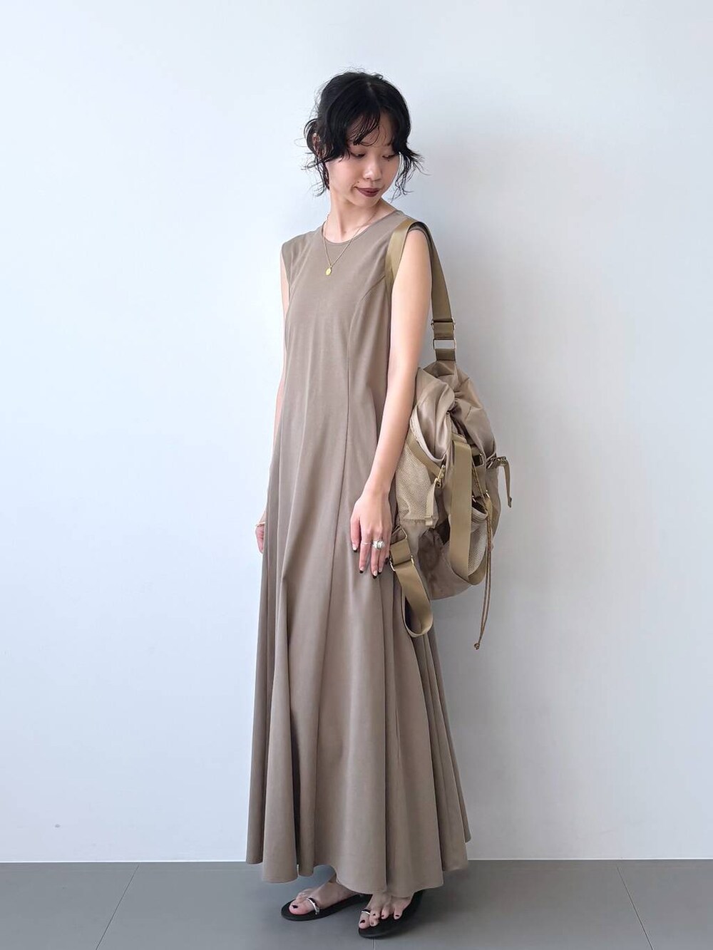 ブラック系のサンダル、ブラウン系のワンピース、ベージュ系のバックパック/リュックを着用したレディースの夏コーディネートの8枚目の写真