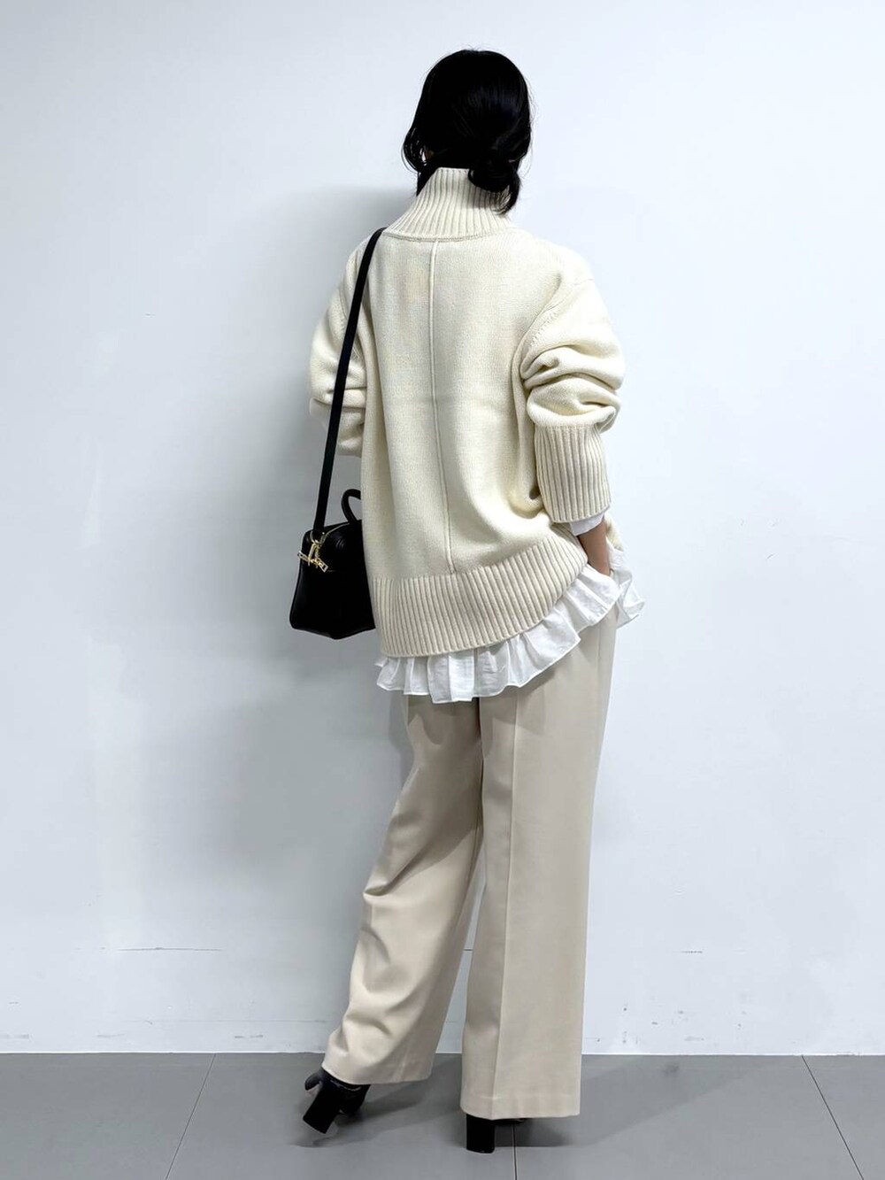 ブラック系のブーツ、ベージュ系のその他パンツ、ブラック系のボストンバッグを着用したレディースの冬コーディネートの5枚目の写真