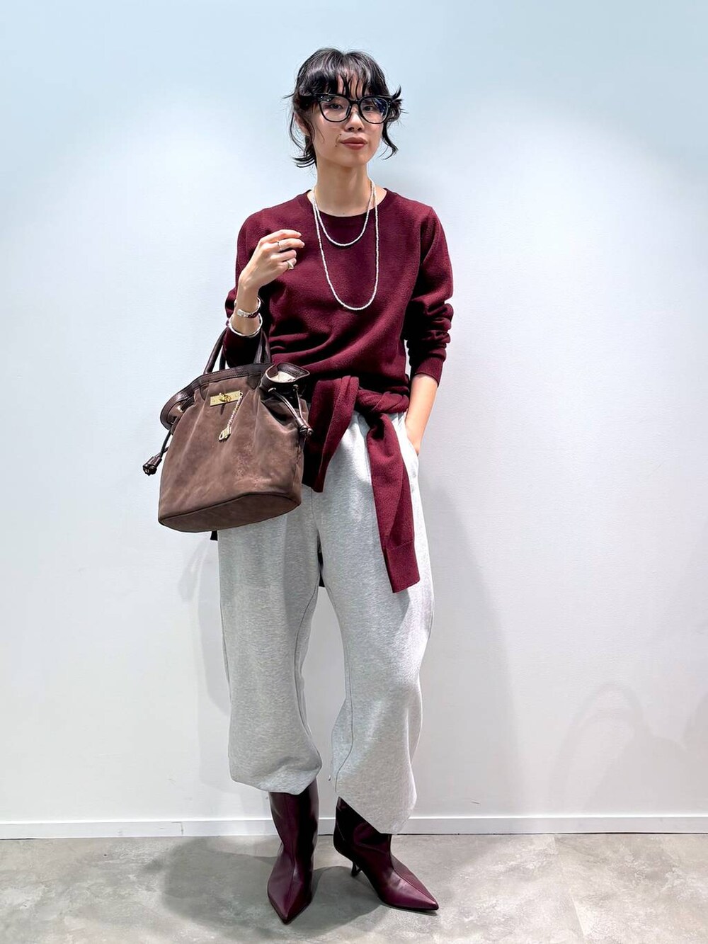 レッド系のニット/セーター、レッド系のカーディガン/ボレロ、グレー系のスウェットパンツを着用したレディースの秋コーディネートの5枚目の写真
