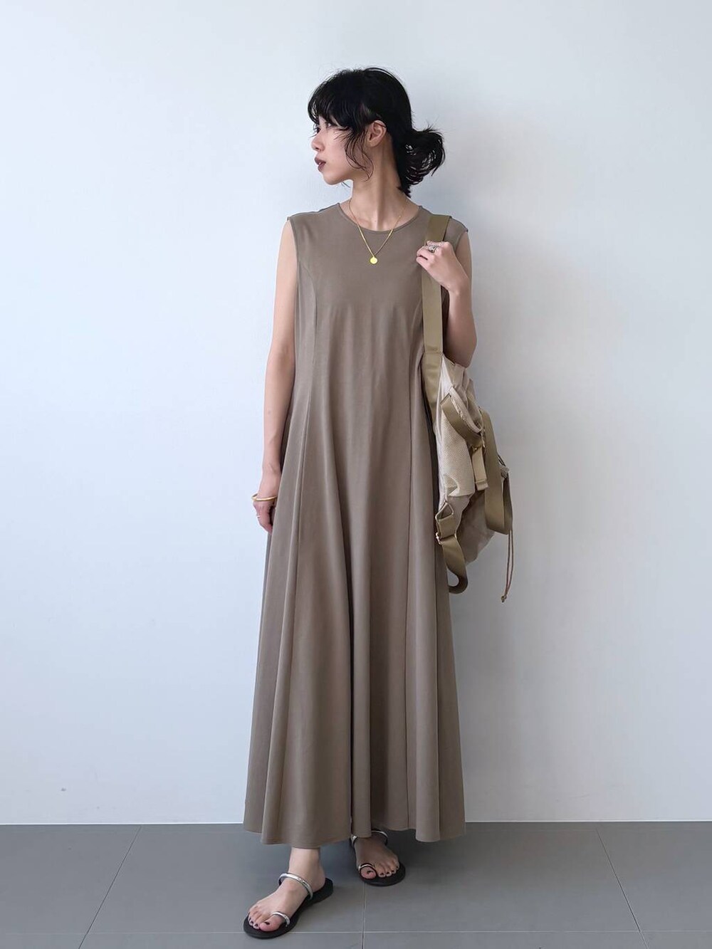 ブラック系のサンダル、ブラウン系のワンピース、ベージュ系のバックパック/リュックを着用したレディースの夏コーディネートの2枚目の写真