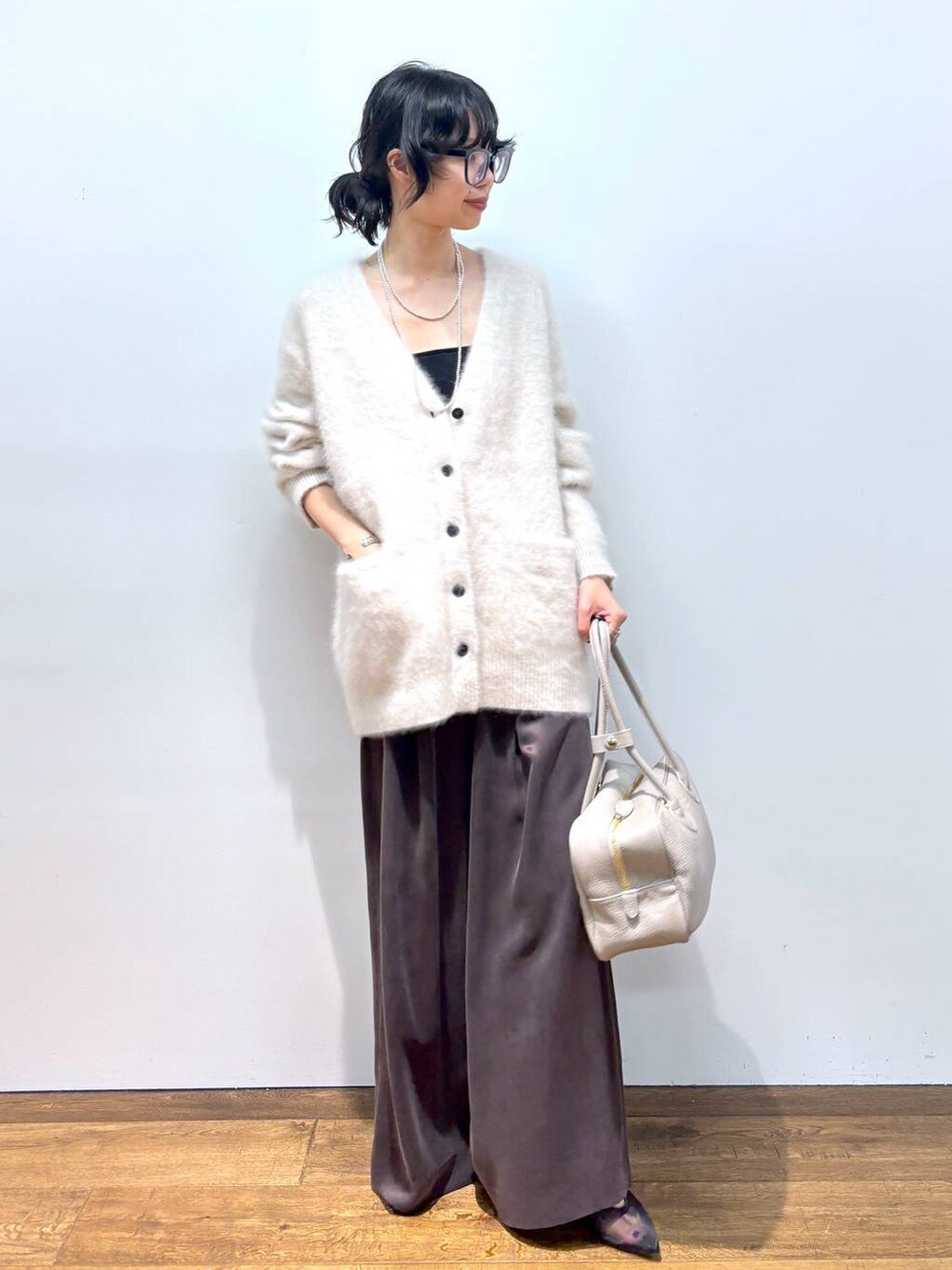 ホワイト系のカーディガン/ボレロ、ブラック系のパンプス、ブラウン系のその他パンツを着用したレディースの秋コーディネートの9枚目の写真