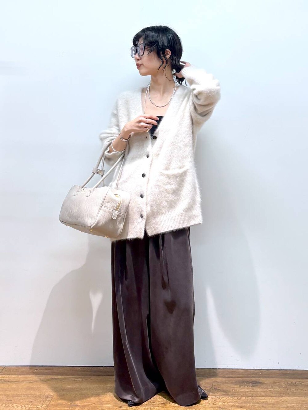 ホワイト系のカーディガン/ボレロ、ブラック系のパンプス、ブラウン系のその他パンツを着用したレディースの秋コーディネートの5枚目の写真