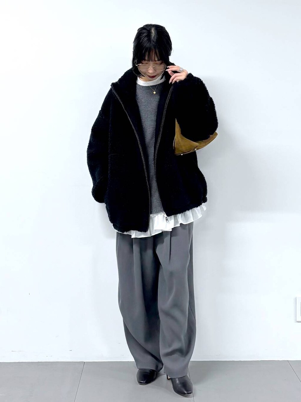 グレー系のその他パンツ、グレー系のニット/セーター、ブラック系のブーツを着用したレディースの冬コーディネートの5枚目の写真