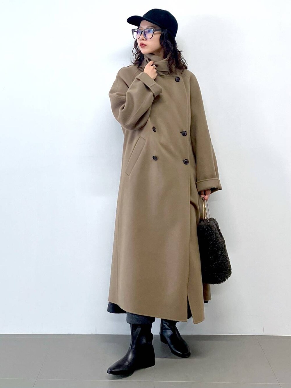 グレー系のハンドバッグ、グレー系のカーディガン/ボレロ、グリーン系のステンカラーコートを着用したレディースの秋コーディネートの2枚目の写真