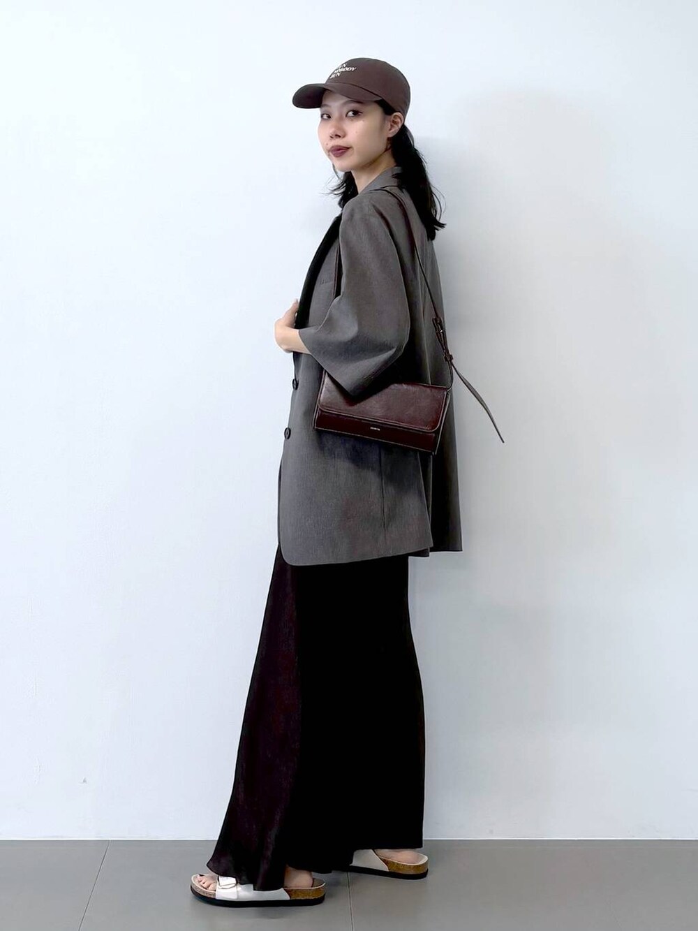 ホワイト系のサンダル、ブラック系のキャミソール、グレー系のテーラードジャケットを着用したレディースの春コーディネートの9枚目の写真