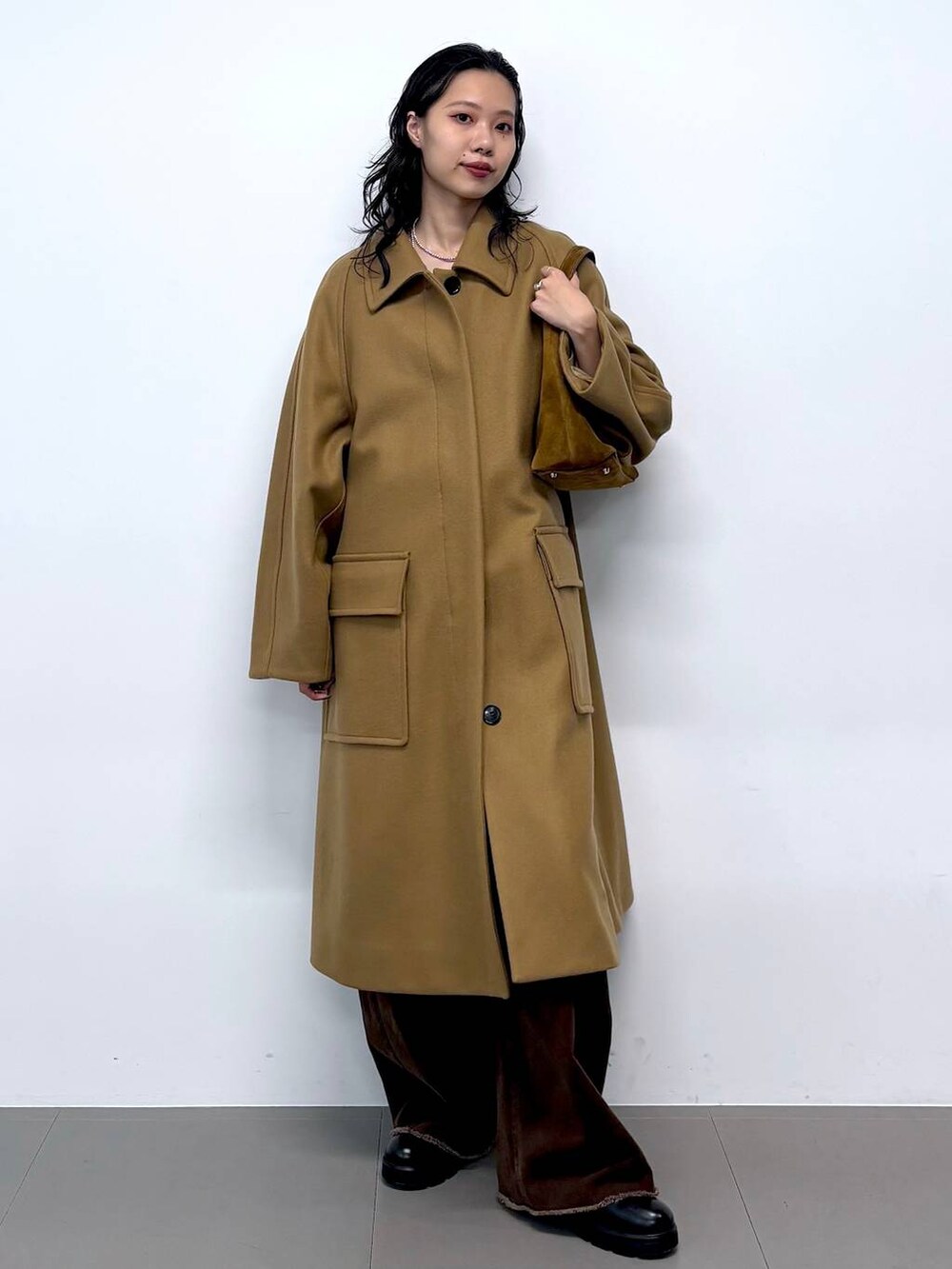 ブルー系のニット/セーター、ブラック系のサンダル、イエロー系のステンカラーコートを着用したレディースの秋コーディネートの8枚目の写真