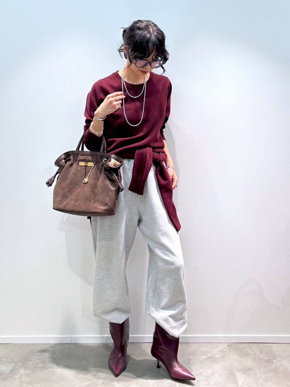 レッド系のニット/セーター、レッド系のカーディガン/ボレロ、グレー系のスウェットパンツを着用したレディースの秋コーディネートの2枚目の写真