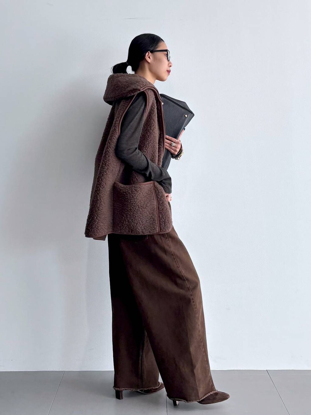 グレー系のカーディガン/ボレロ、ブラウン系のブーツ、ブラック系のハンドバッグを着用したレディースの秋コーディネートの9枚目の写真