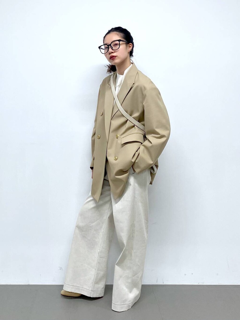 ホワイト系のショルダーバッグ、ベージュ系のテーラードジャケット、グレー系のサロペット/オーバーオールを着用したレディースの冬コーディネートの8枚目の写真