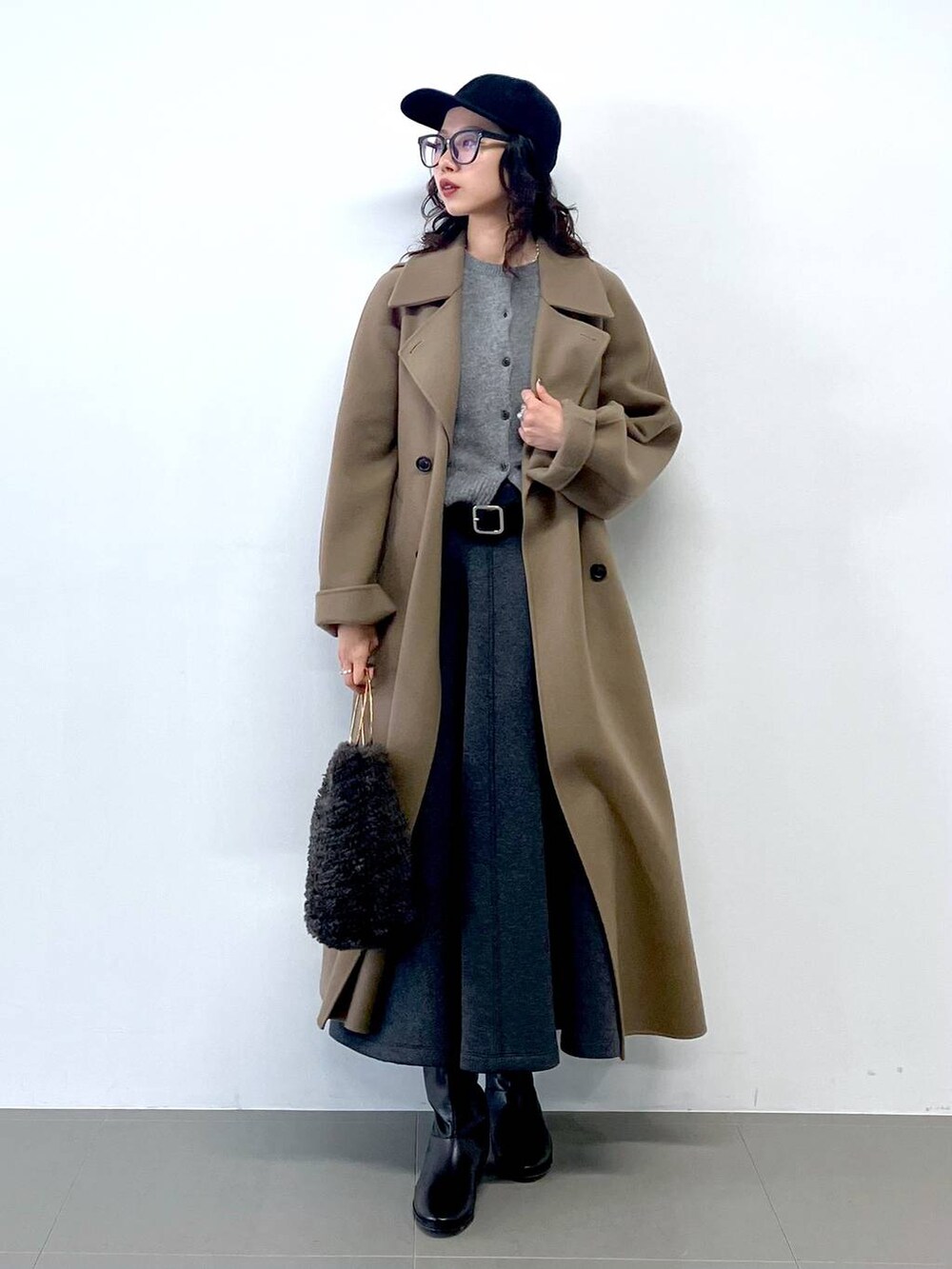 グレー系のハンドバッグ、グレー系のカーディガン/ボレロ、グリーン系のステンカラーコートを着用したレディースの秋コーディネートの4枚目の写真