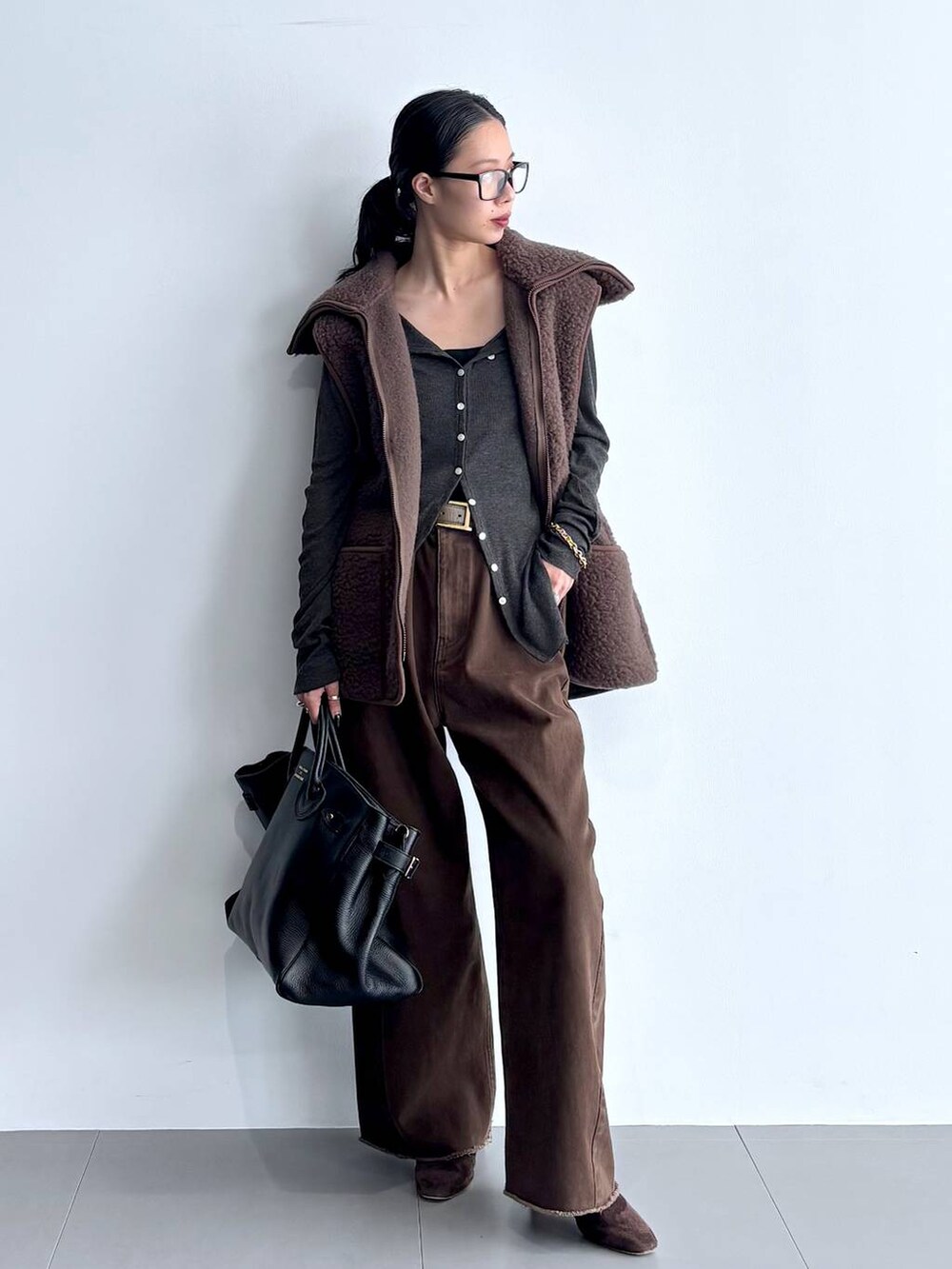 グレー系のカーディガン/ボレロ、ブラウン系のブーツ、ブラック系のハンドバッグを着用したレディースの秋コーディネートの7枚目の写真
