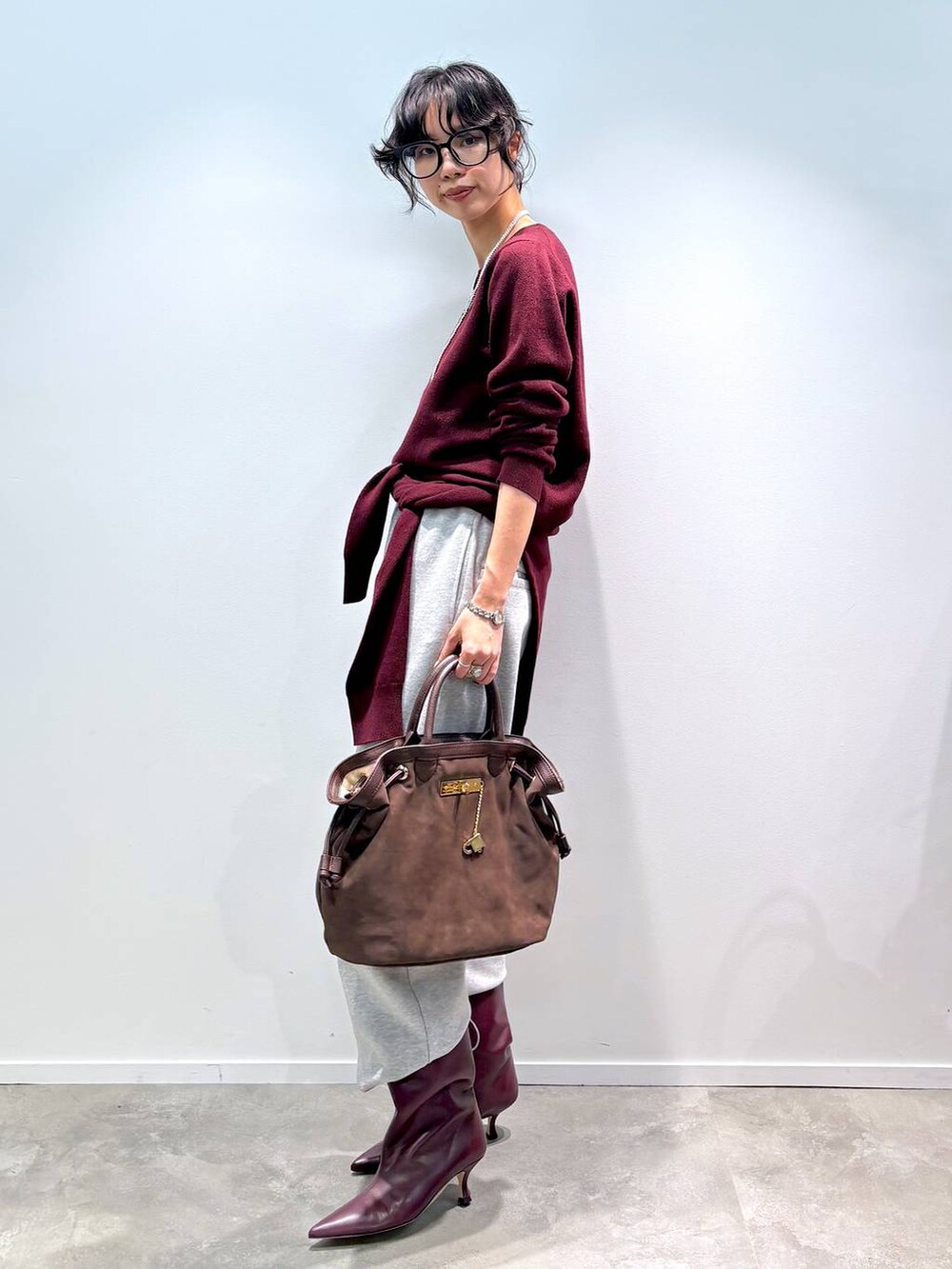 レッド系のニット/セーター、レッド系のカーディガン/ボレロ、グレー系のスウェットパンツを着用したレディースの秋コーディネートの7枚目の写真