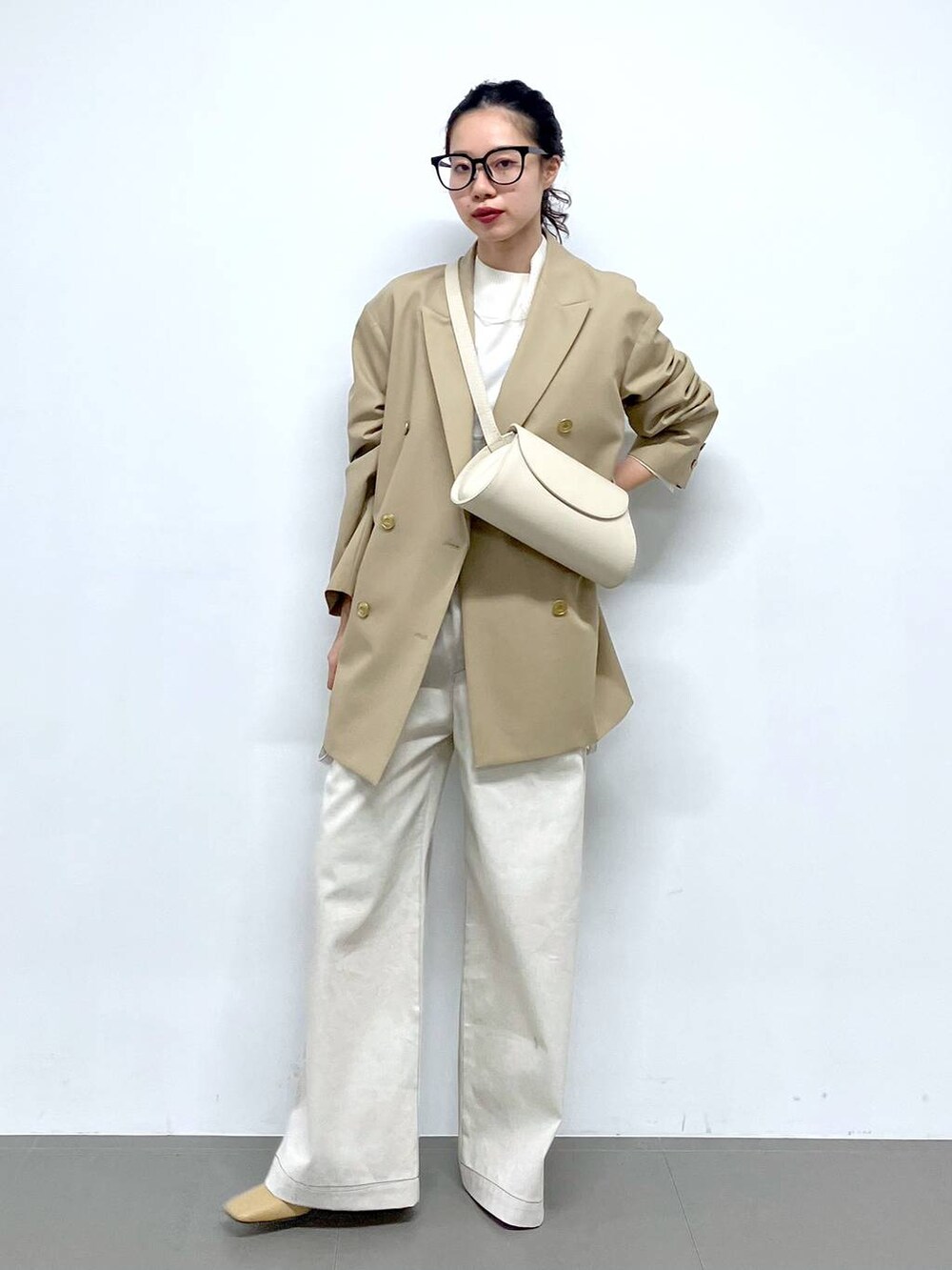 ホワイト系のショルダーバッグ、ベージュ系のテーラードジャケット、グレー系のサロペット/オーバーオールを着用したレディースの冬コーディネートの4枚目の写真