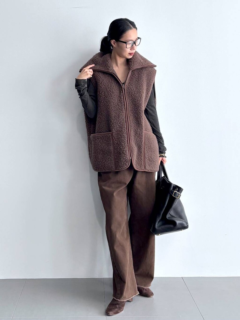 グレー系のカーディガン/ボレロ、ブラウン系のブーツ、ブラック系のハンドバッグを着用したレディースの秋コーディネートの8枚目の写真