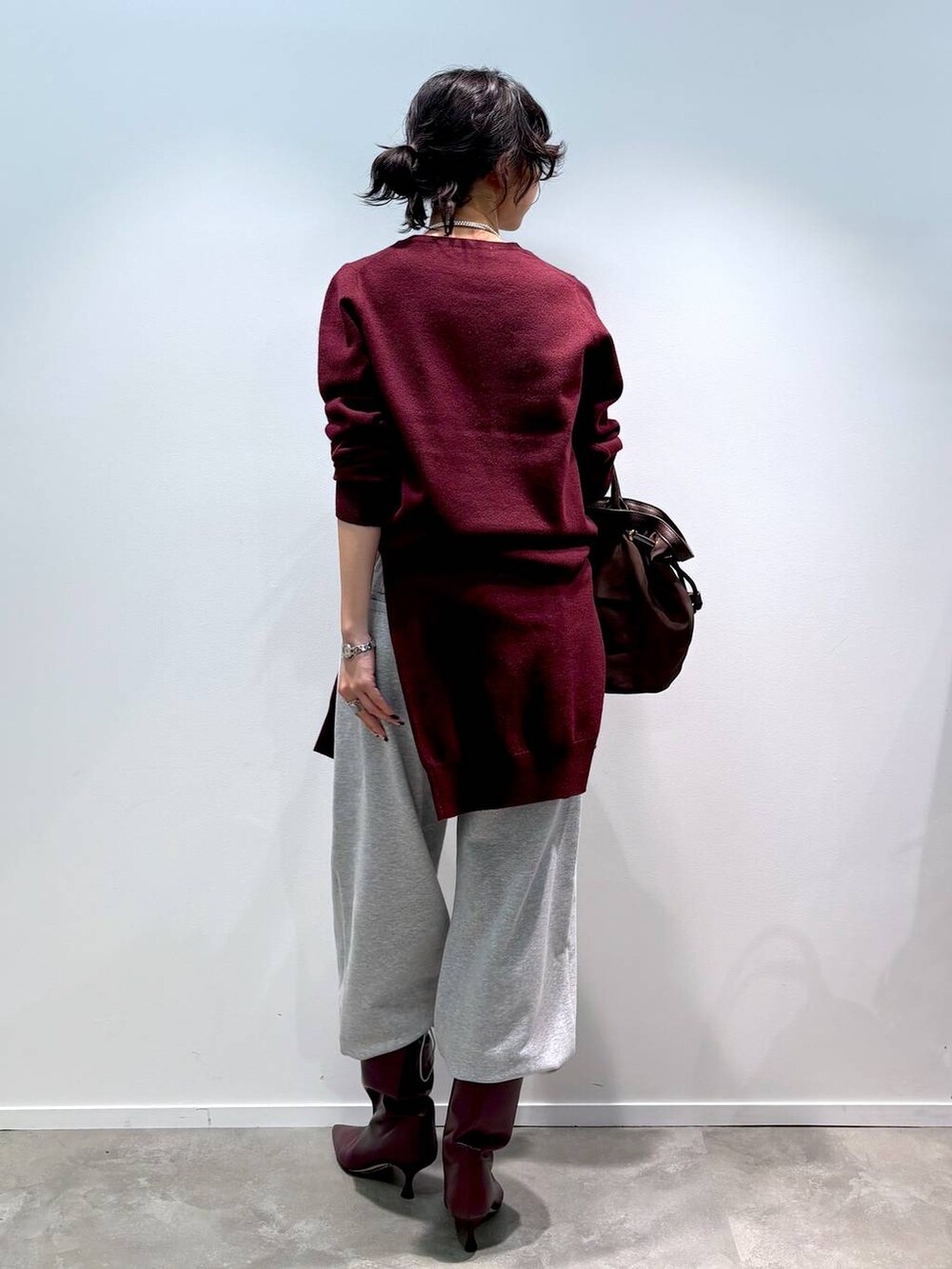 レッド系のニット/セーター、レッド系のカーディガン/ボレロ、グレー系のスウェットパンツを着用したレディースの秋コーディネートの3枚目の写真