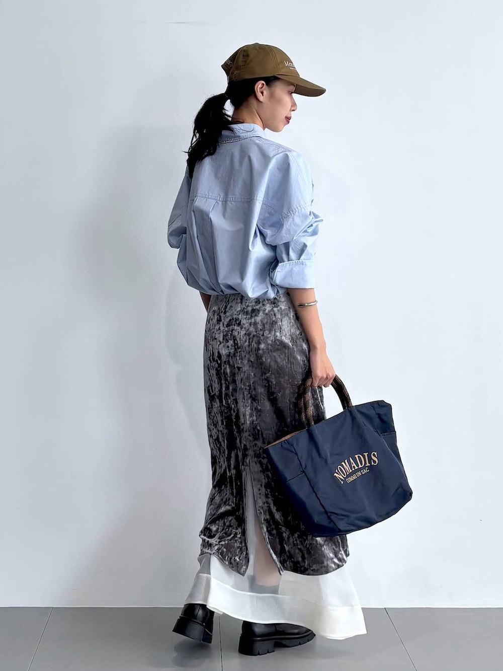 ブラック系のブーツ、グレー系のスカート、ブルー系のトートバッグを着用したレディースの秋コーディネートの7枚目の写真