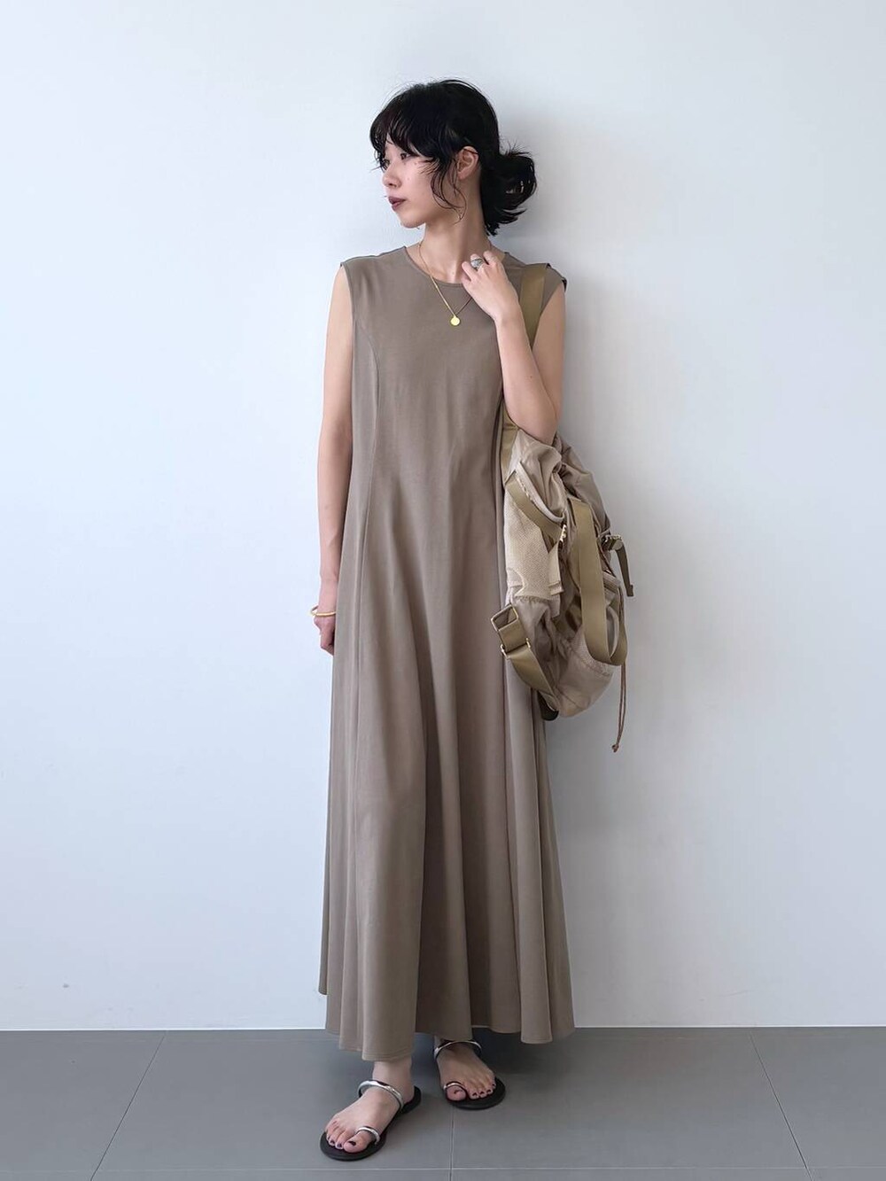 ブラック系のサンダル、ブラウン系のワンピース、ベージュ系のバックパック/リュックを着用したレディースの夏コーディネートの6枚目の写真