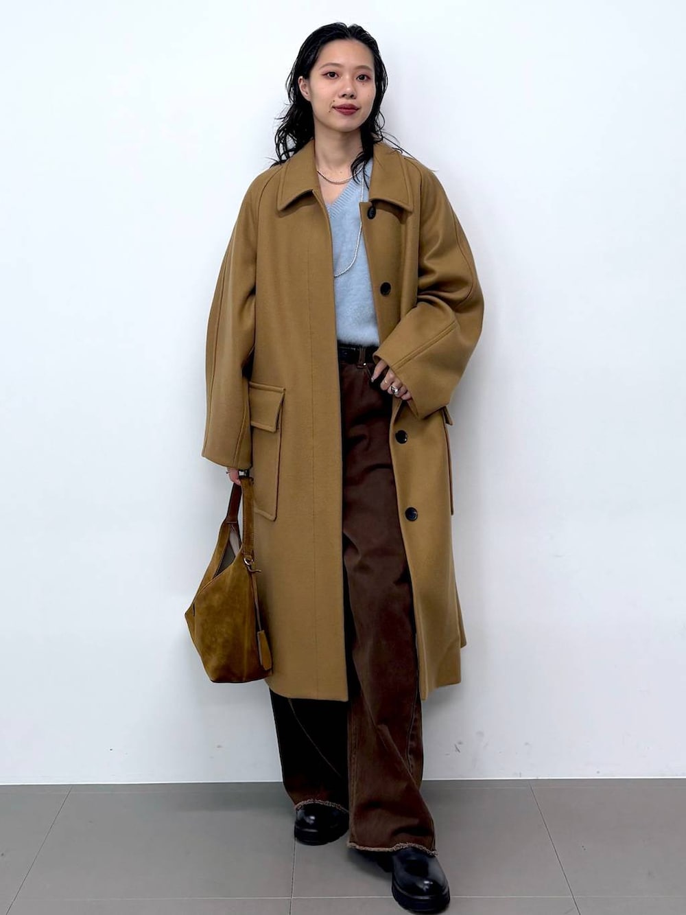 ブルー系のニット/セーター、ブラック系のサンダル、イエロー系のステンカラーコートを着用したレディースの秋コーディネートの4枚目の写真