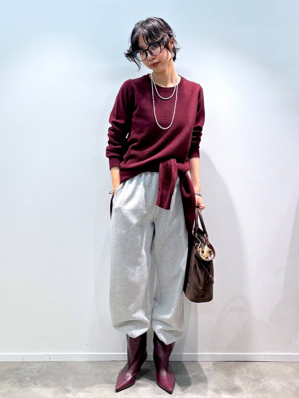 レッド系のニット/セーター、レッド系のカーディガン/ボレロ、グレー系のスウェットパンツを着用したレディースの秋コーディネートの6枚目の写真