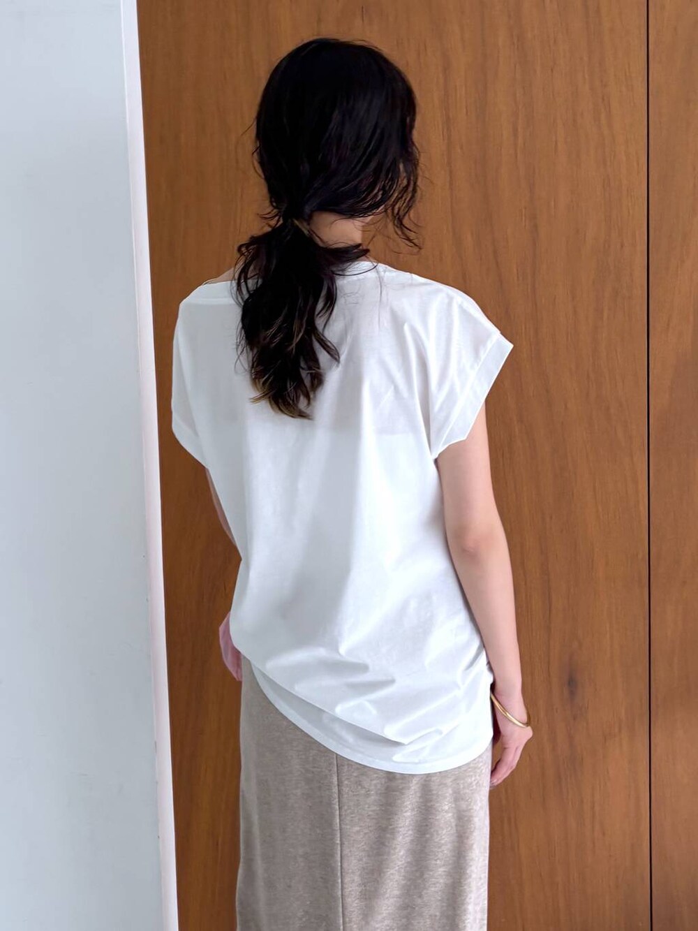 イエロー系のスリッポン、ホワイト系のTシャツ/カットソー、ベージュ系のスカートを着用したレディースの秋コーディネートの4枚目の写真