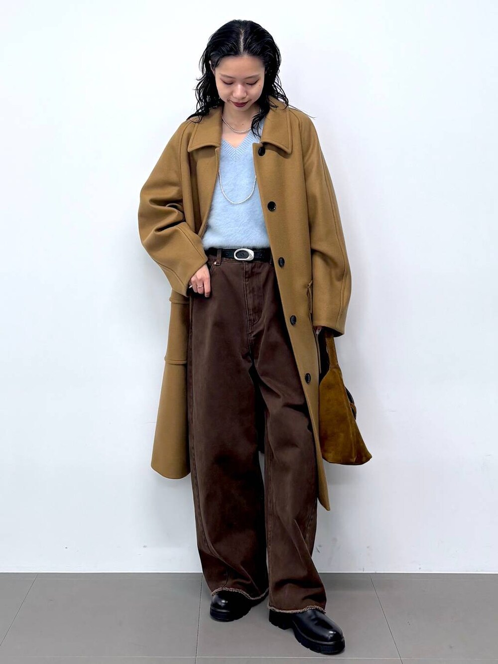 ブルー系のニット/セーター、ブラック系のサンダル、イエロー系のステンカラーコートを着用したレディースの秋コーディネートの2枚目の写真