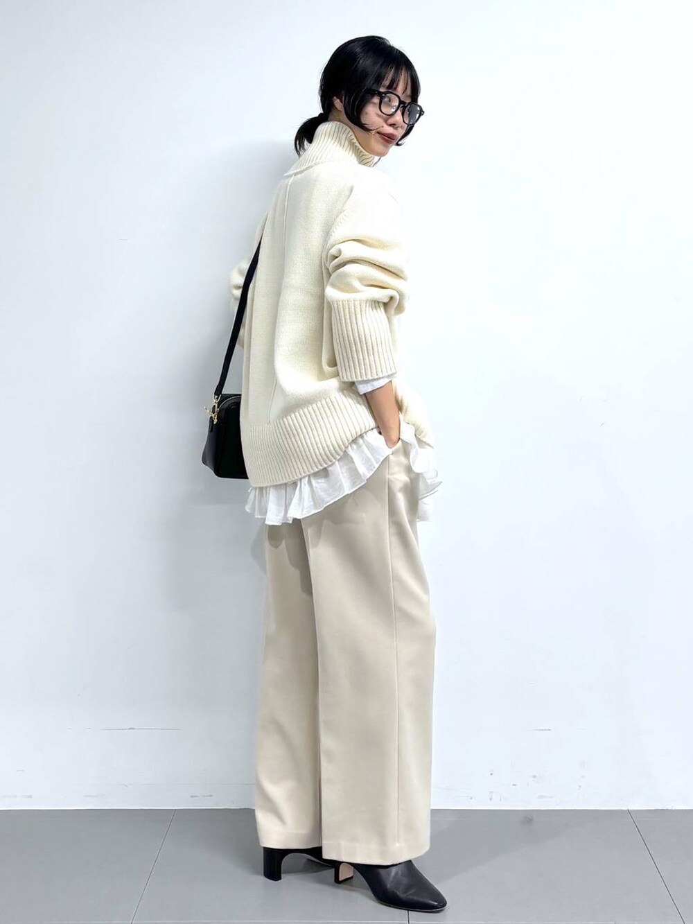 ブラック系のブーツ、ベージュ系のその他パンツ、ブラック系のボストンバッグを着用したレディースの冬コーディネートの2枚目の写真