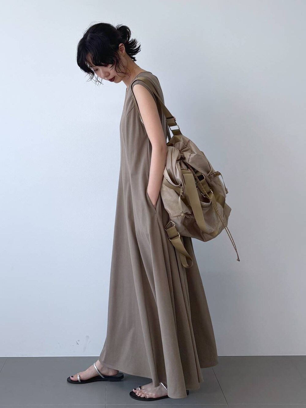 ブラック系のサンダル、ブラウン系のワンピース、ベージュ系のバックパック/リュックを着用したレディースの夏コーディネートの5枚目の写真
