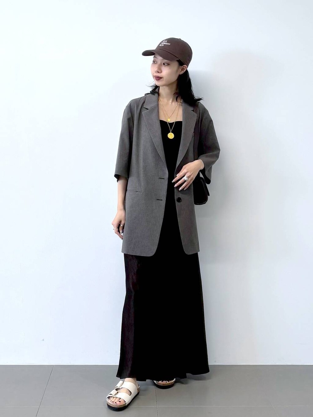 ホワイト系のサンダル、ブラック系のキャミソール、グレー系のテーラードジャケットを着用したレディースの春コーディネートの6枚目の写真