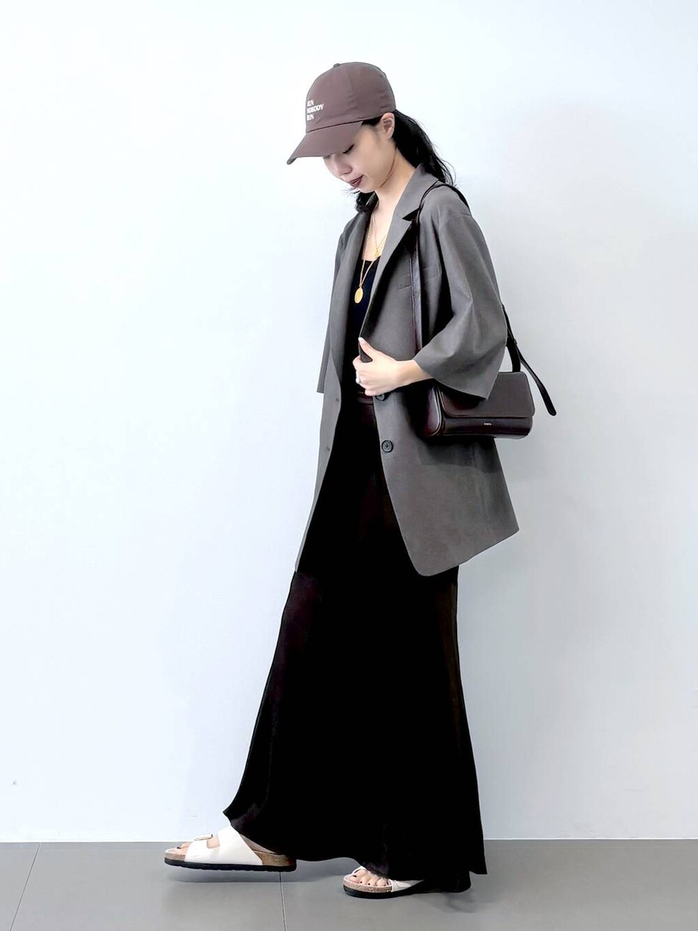 ホワイト系のサンダル、ブラック系のキャミソール、グレー系のテーラードジャケットを着用したレディースの春コーディネートの5枚目の写真