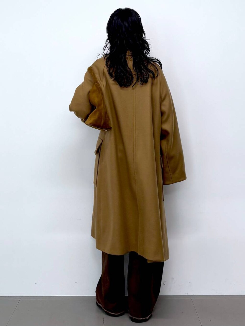 ブルー系のニット/セーター、ブラック系のサンダル、イエロー系のステンカラーコートを着用したレディースの秋コーディネートの6枚目の写真