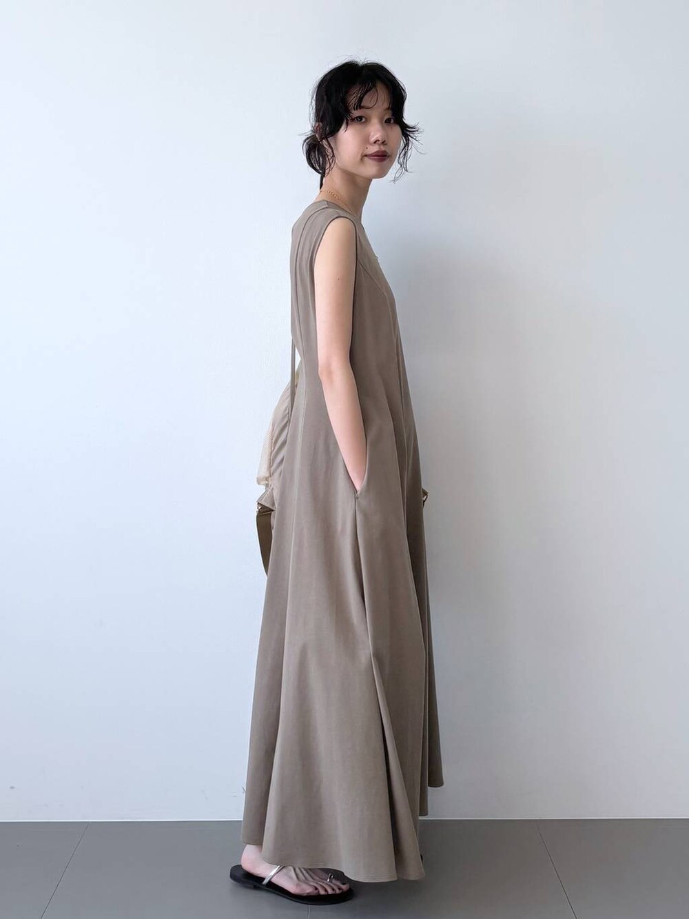 ブラック系のサンダル、ブラウン系のワンピース、ベージュ系のバックパック/リュックを着用したレディースの夏コーディネートの3枚目の写真