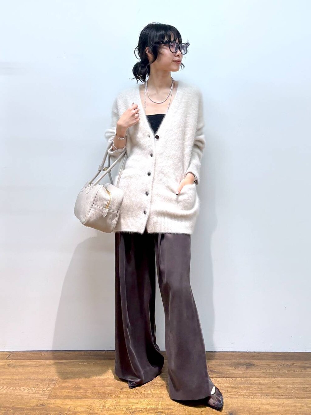 ホワイト系のカーディガン/ボレロ、ブラック系のパンプス、ブラウン系のその他パンツを着用したレディースの秋コーディネートの6枚目の写真