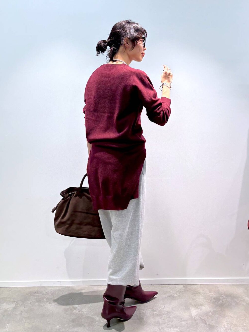 レッド系のニット/セーター、レッド系のカーディガン/ボレロ、グレー系のスウェットパンツを着用したレディースの秋コーディネートの4枚目の写真
