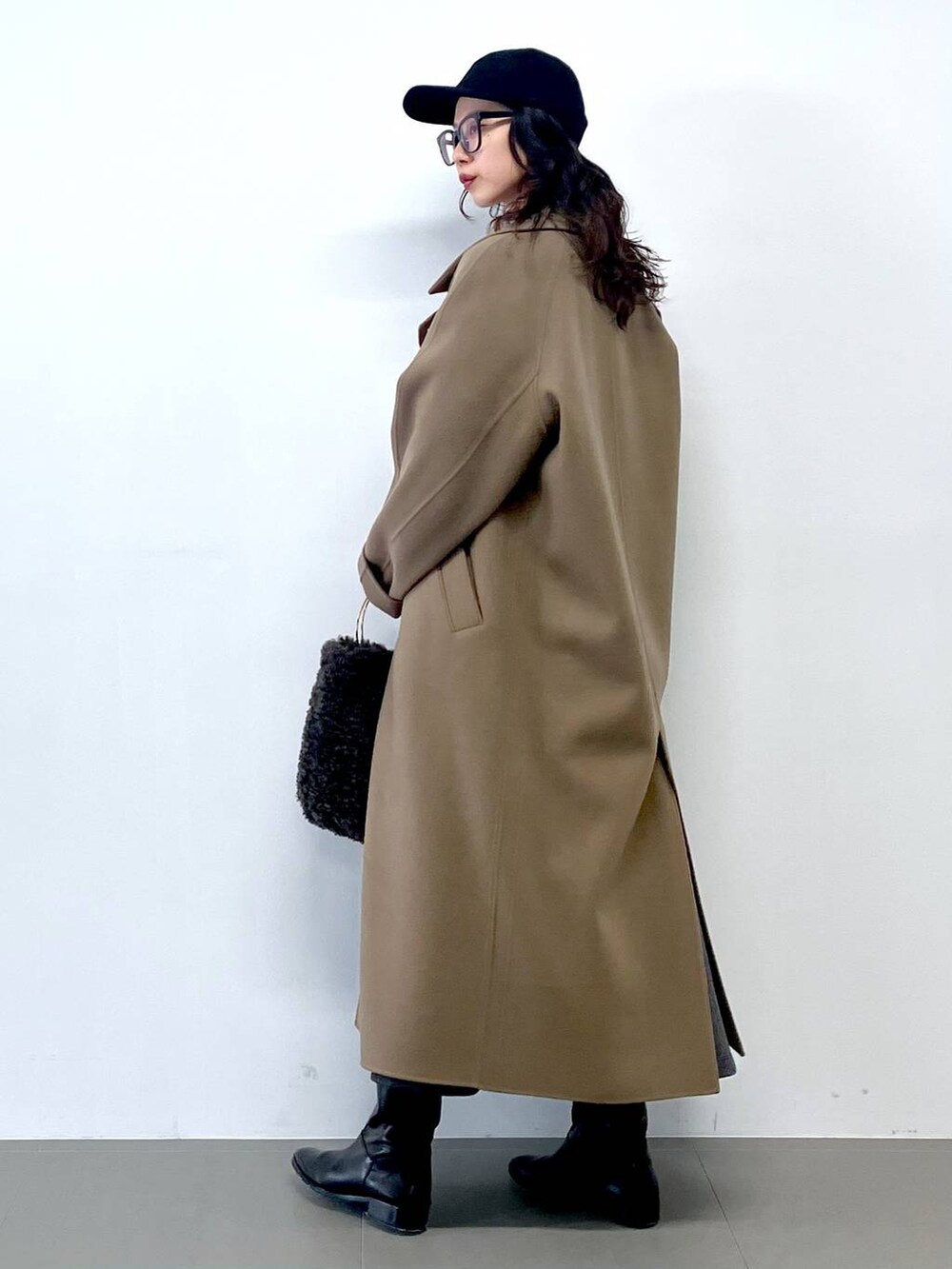 グレー系のハンドバッグ、グレー系のカーディガン/ボレロ、グリーン系のステンカラーコートを着用したレディースの秋コーディネートの3枚目の写真