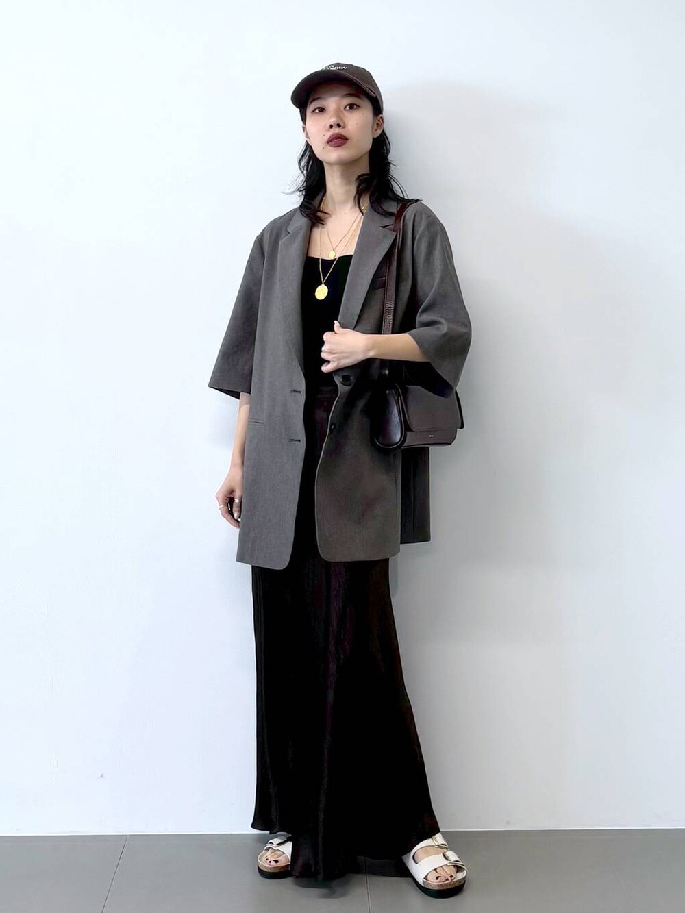 ホワイト系のサンダル、ブラック系のキャミソール、グレー系のテーラードジャケットを着用したレディースの春コーディネートの8枚目の写真