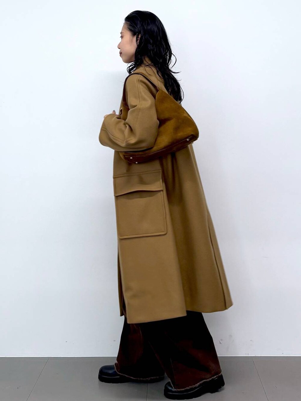 ブルー系のニット/セーター、ブラック系のサンダル、イエロー系のステンカラーコートを着用したレディースの秋コーディネートの3枚目の写真