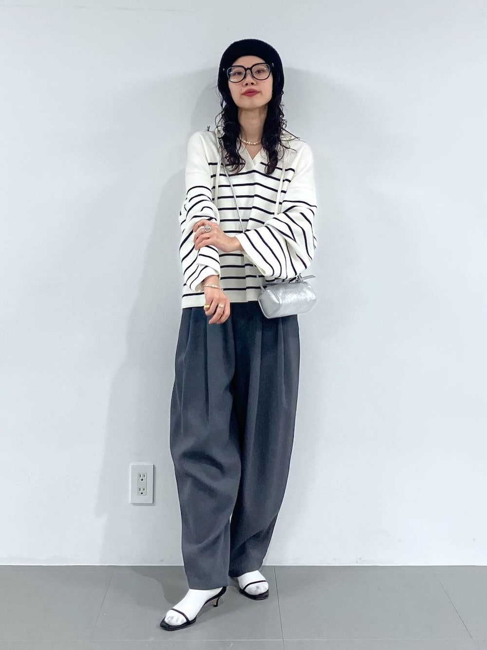 シルバー系のショルダーバッグ、グレー系のその他パンツ、ホワイト系のニット/セーターを着用したレディースの冬コーディネートの2枚目の写真