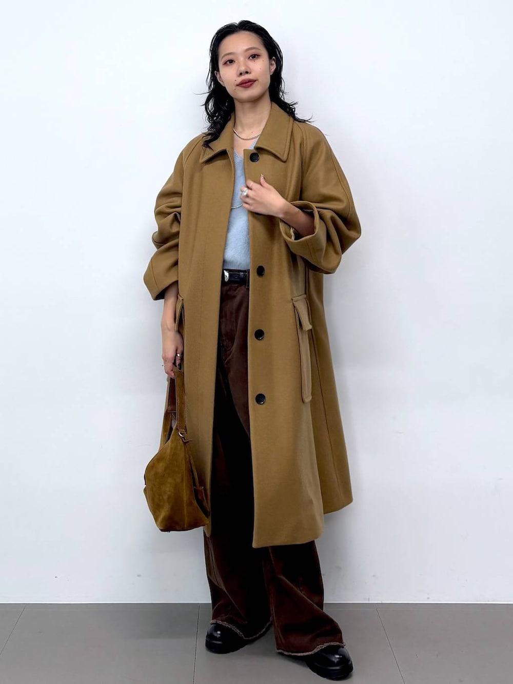 ブルー系のニット/セーター、ブラック系のサンダル、イエロー系のステンカラーコートを着用したレディースの秋コーディネートの5枚目の写真