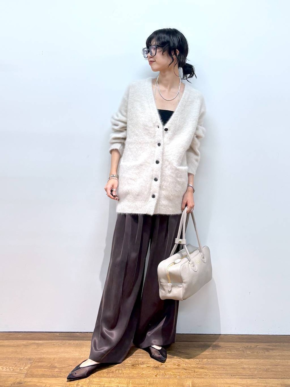 ホワイト系のカーディガン/ボレロ、ブラック系のパンプス、ブラウン系のその他パンツを着用したレディースの秋コーディネートの2枚目の写真