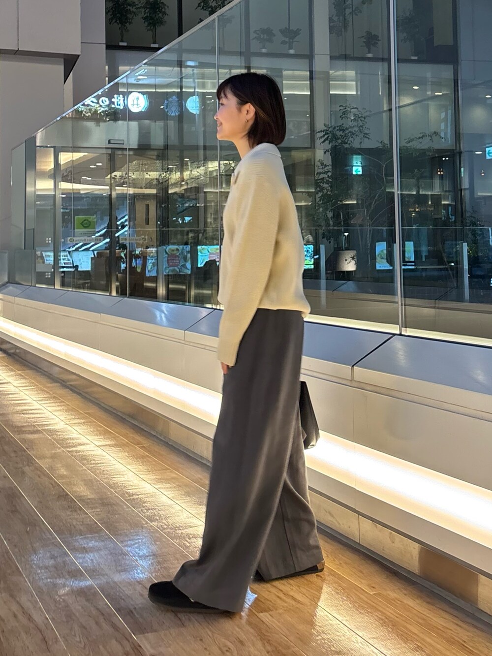 グレー系のニット/セーター、ホワイト系のTシャツ/カットソー、ブラック系のサンダルを着用したレディースの冬コーディネートの7枚目の写真