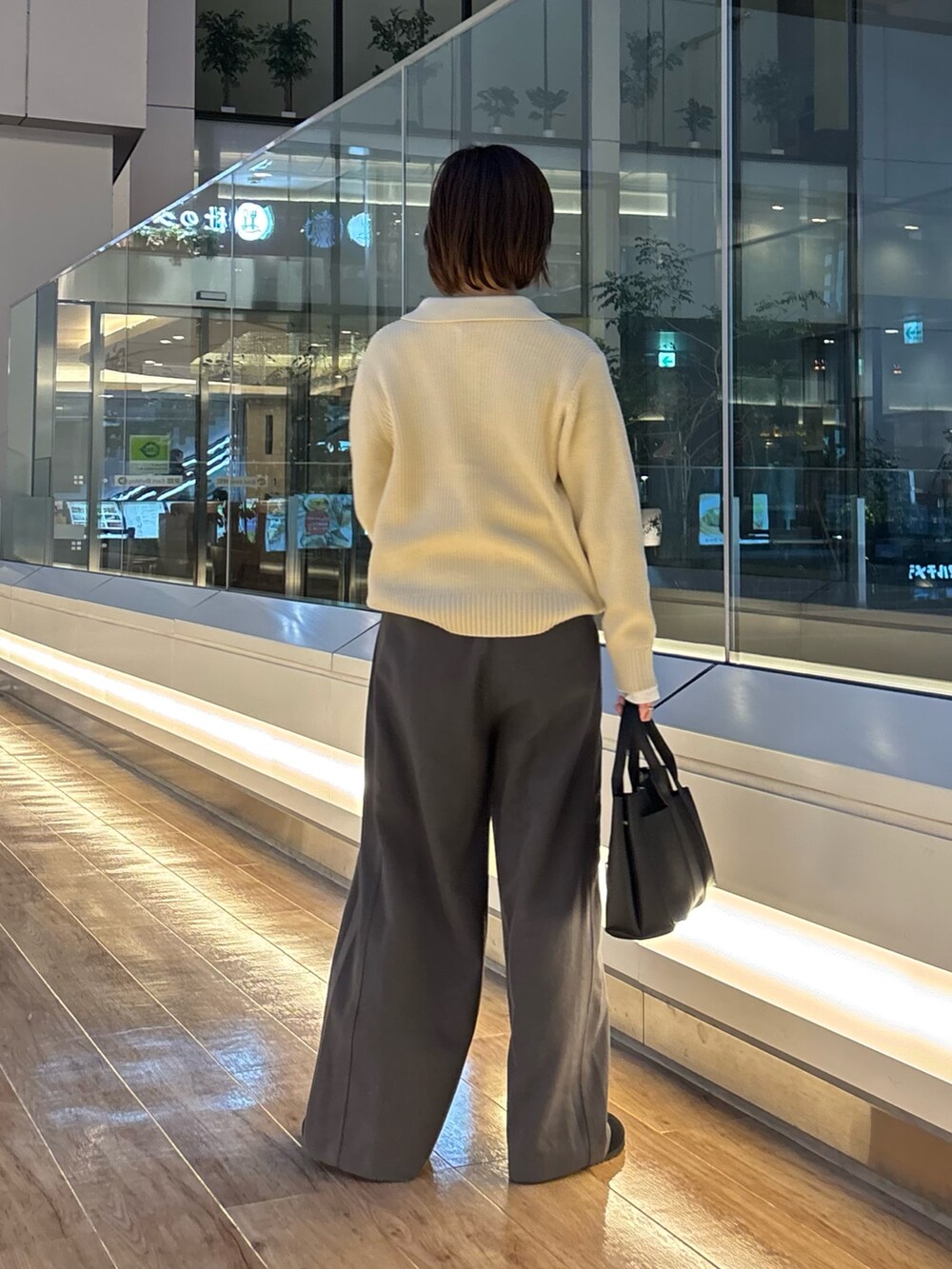 グレー系のニット/セーター、ホワイト系のTシャツ/カットソー、ブラック系のサンダルを着用したレディースの冬コーディネートの6枚目の写真