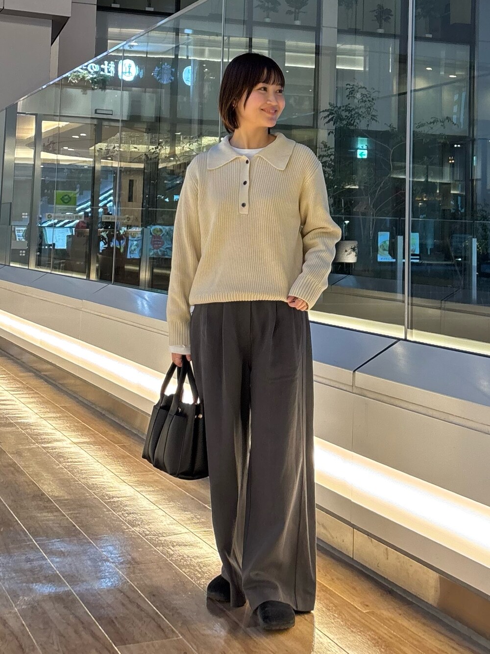 グレー系のニット/セーター、ホワイト系のTシャツ/カットソー、ブラック系のサンダルを着用したレディースの冬コーディネートの9枚目の写真