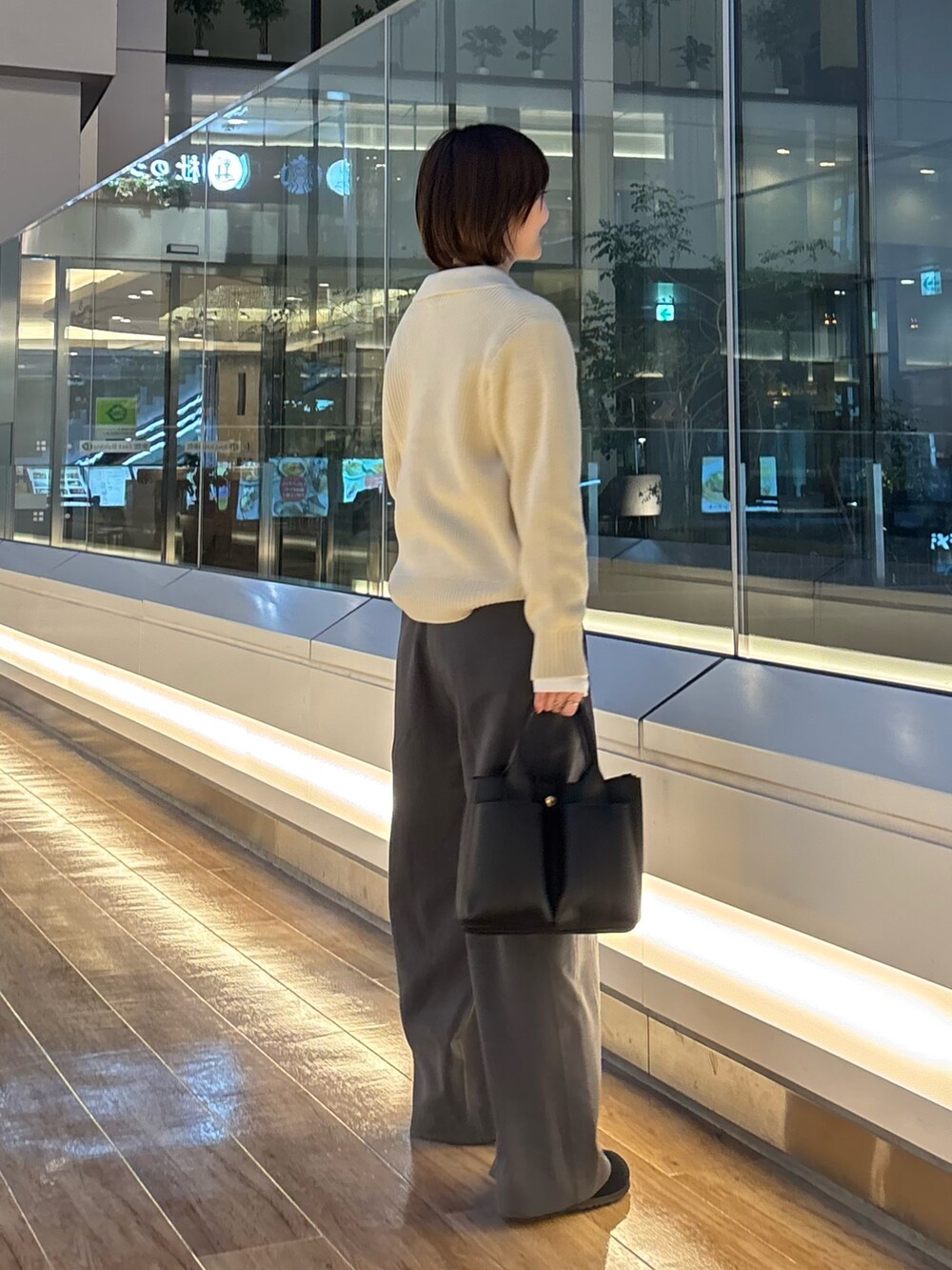 グレー系のニット/セーター、ホワイト系のTシャツ/カットソー、ブラック系のサンダルを着用したレディースの冬コーディネートの5枚目の写真