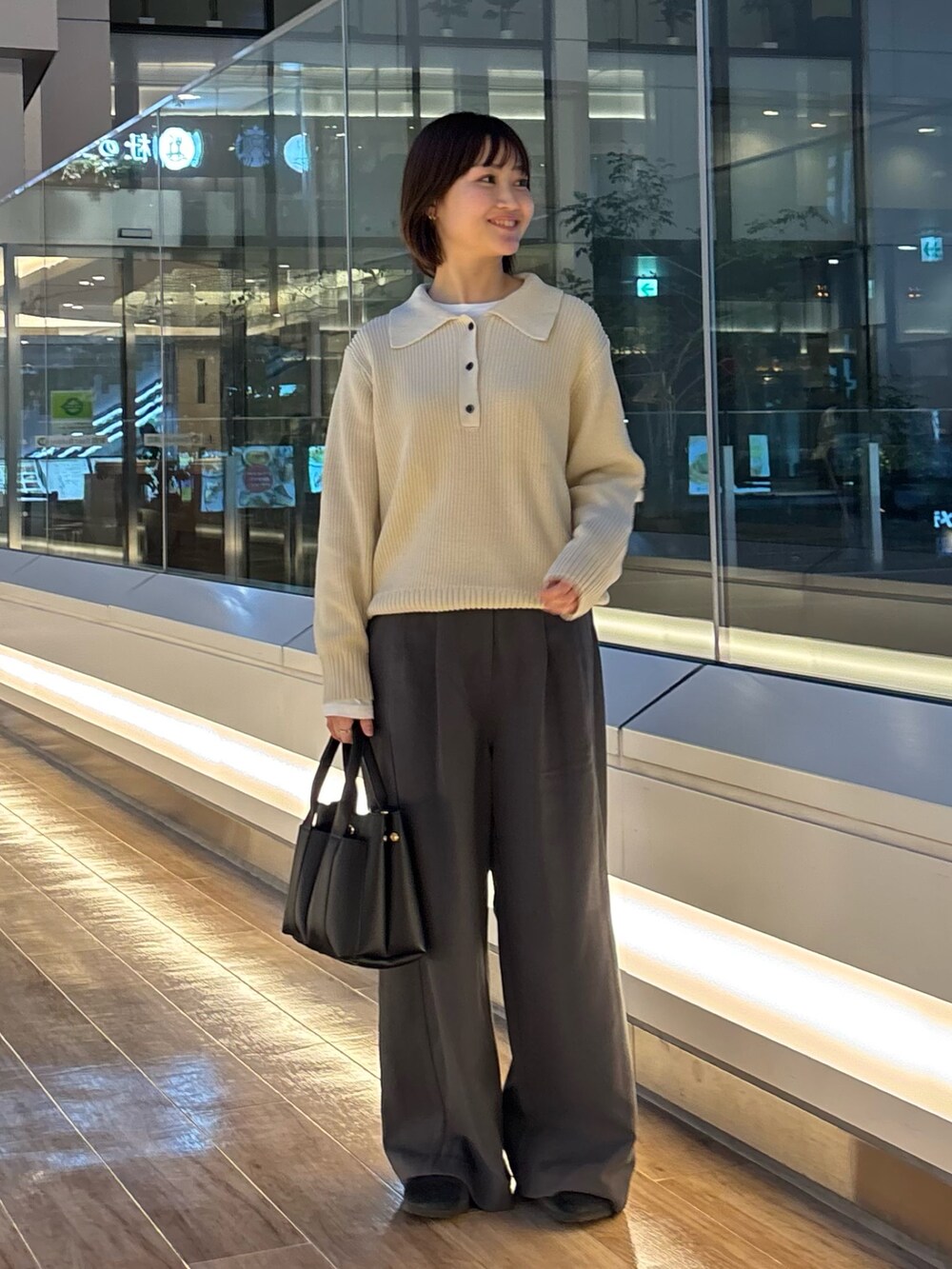 グレー系のニット/セーター、ホワイト系のTシャツ/カットソー、ブラック系のサンダルを着用したレディースの冬コーディネートの2枚目の写真