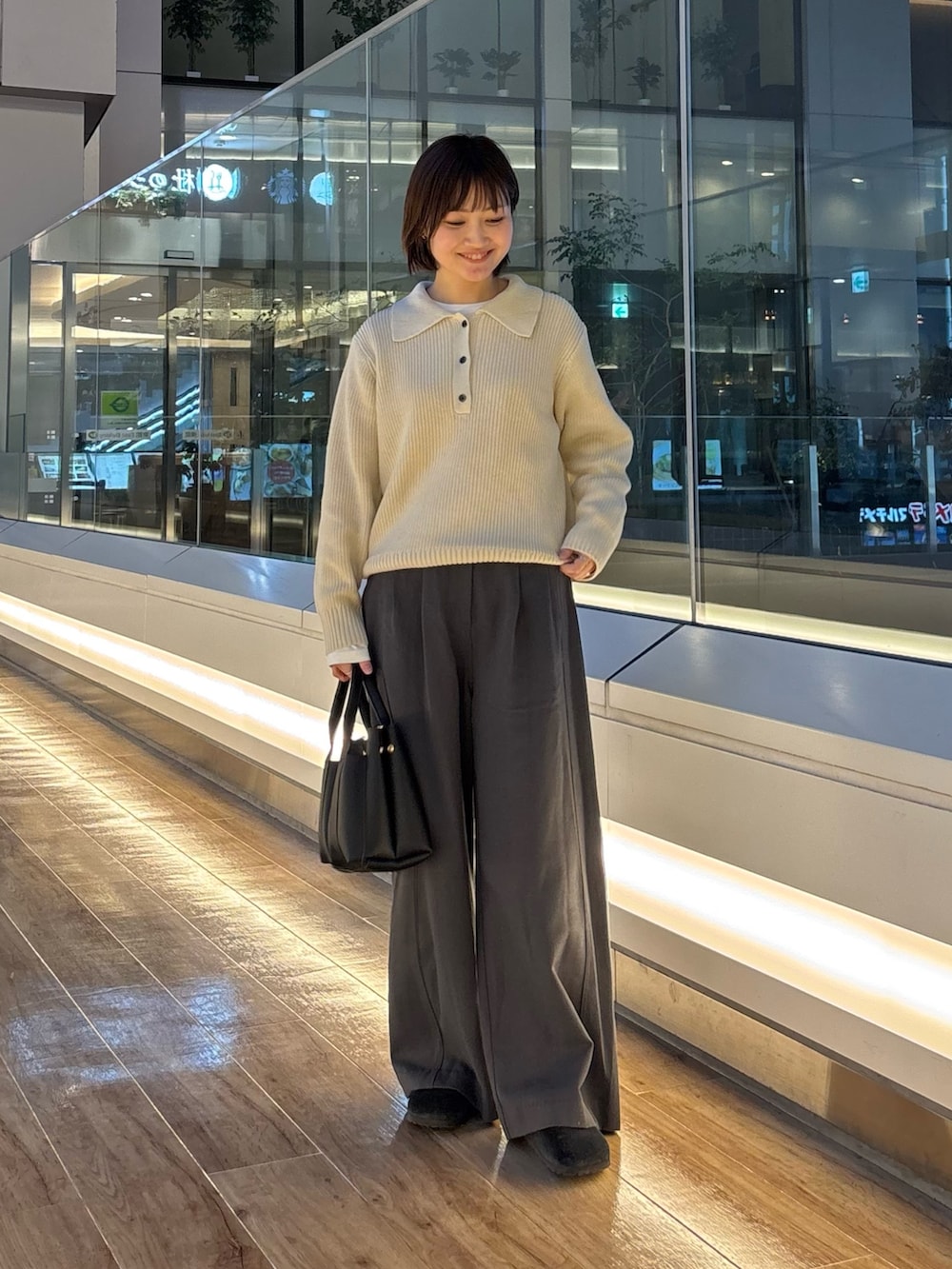 グレー系のニット/セーター、ホワイト系のTシャツ/カットソー、ブラック系のサンダルを着用したレディースの冬コーディネートの3枚目の写真