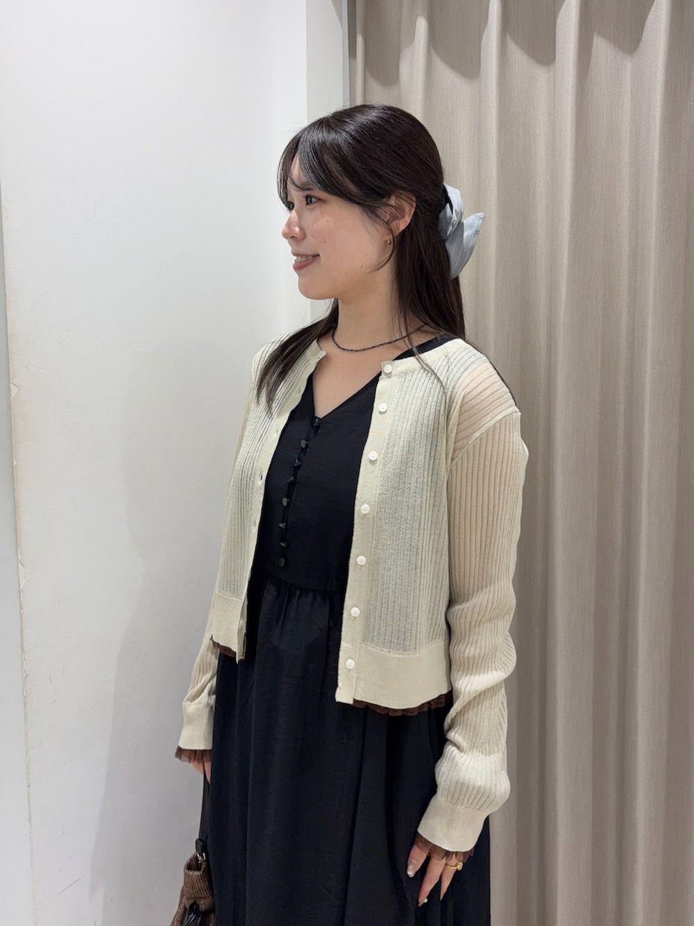 ベージュ系のカーディガン/ボレロ、ブラック系のワンピース、ブラック系のローファーを着用したレディースの春コーディネートの3枚目の写真