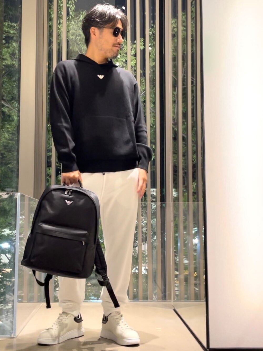 「EMPORIO ARMANI、エンポリオアルマーニ、パーカー、ニットパーカー、ワンポイント、ロゴ、フーディー、白スニーカー、スウェット、スウェットパンツ、バックパック、リュック、休日スタイル、秋コーデ、今日のコーデ」|「EMPORIO ARMANIの【エンポリオ アルマーニ】フード付きセーター バージンウール混紡 ミリタリーフォントロゴ刺繍(ニット/セーター、ブラック系)」を使った、じゅんちゃんさん(メンズ・176cm)の秋コーディネートの2枚目の写真