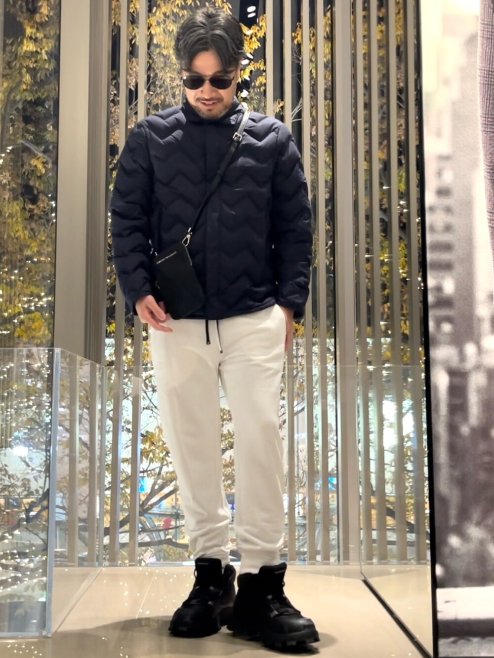 ホワイト系のスウェットパンツ、ブラック系のスニーカー、ブルー系のダウンジャケット/コートを着用したメンズの冬コーディネートの2枚目の写真